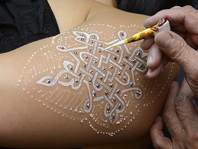 Continue the design with 'white henna' paste